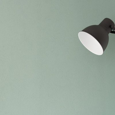 A simple standing lamp against a painted wall.